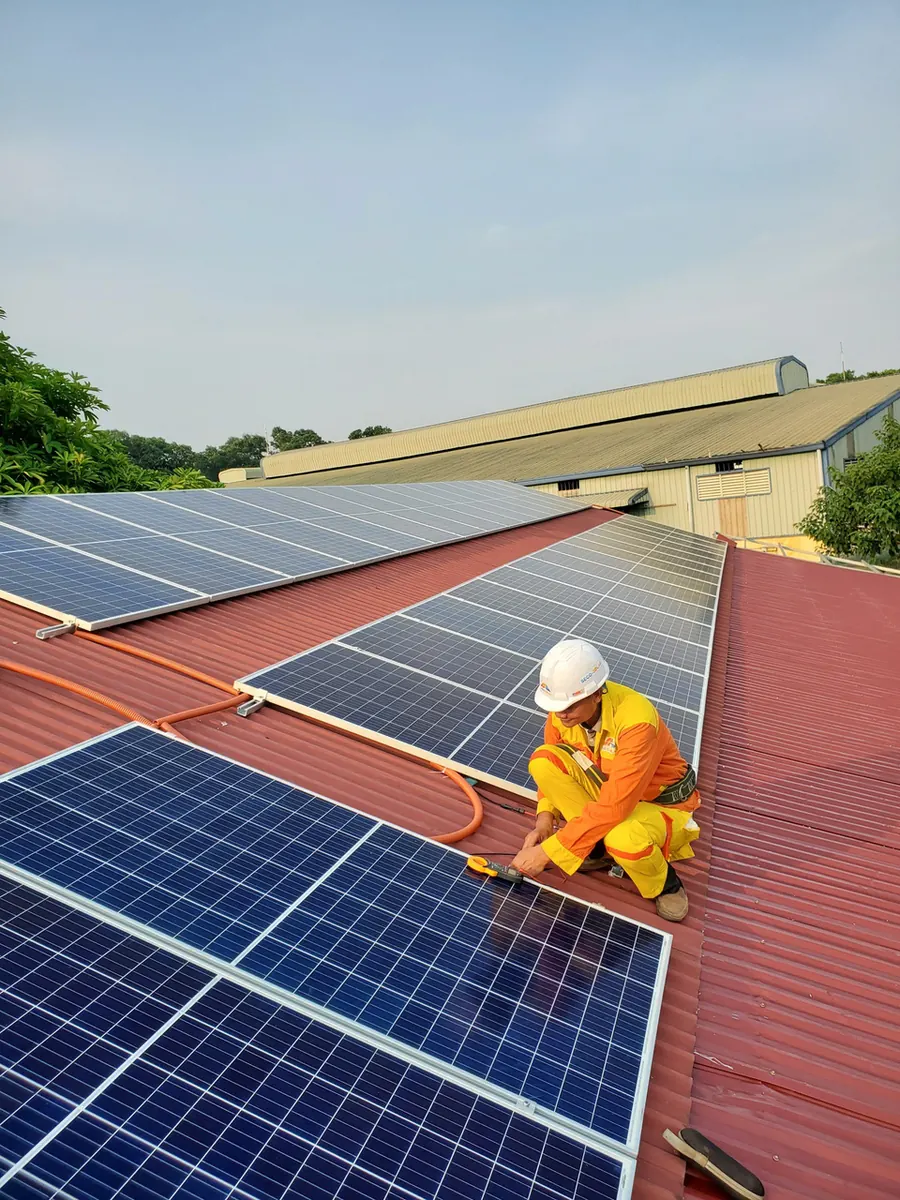 Installer fitting solar panels on a roof